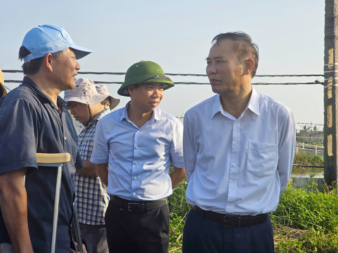 Thứ trưởng Phùng Đức Tiến thăm hỏi, động viên gia đình ông Vũ Văn Quang, hộ dân nuôi tôm có nhiều thiệt hại tại phường Tân Thành, quận Dương Kinh. Ảnh: Đinh Mười.