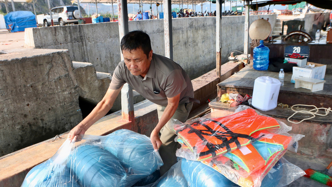 Ông Nguyễn Văn Diễn nhanh tay sắp xếp những phần quà để mang ra khu vực nuôi trồng thủy sản. Ảnh: Nguyễn Thành.