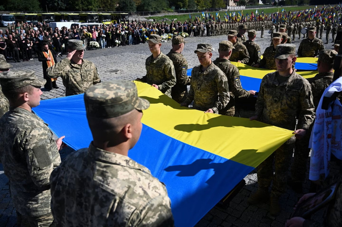 Những binh sĩ Ukraine đặt quốc kỳ lên quan tài của quân nhân thiệt mạng tại Lviv. Ảnh: AFP.