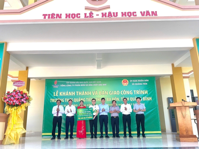 Đại diện PVFCCo trao biển tượng trưng tài trợ 5 tỷ đồng để xây dựng Trường THCS Quảng Tiên. Ảnh: Lê Hằng.