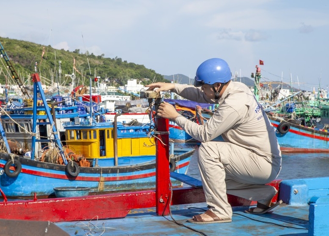 Technicians of Nha Trang Coastal Information Station check the voyage monitoring equipment on fishing boats.