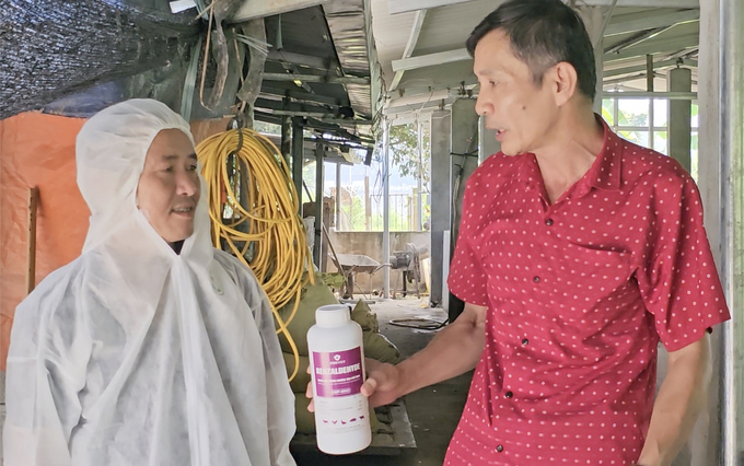 Veterinary staff instruct farmers on how to mix disinfectant. Photo: H.D.