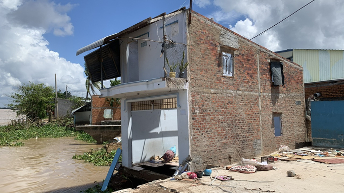 A house belonging to a resident, which has been eroded, precariously sits on the riverbank. Photo: Ho Thao.