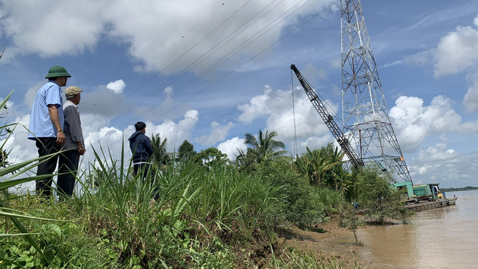 Local authorities and residents of Thanh Long Islet are hiring equipment to reinforce the dikes in areas that frequently experience erosion. Photo: Ho Thao.