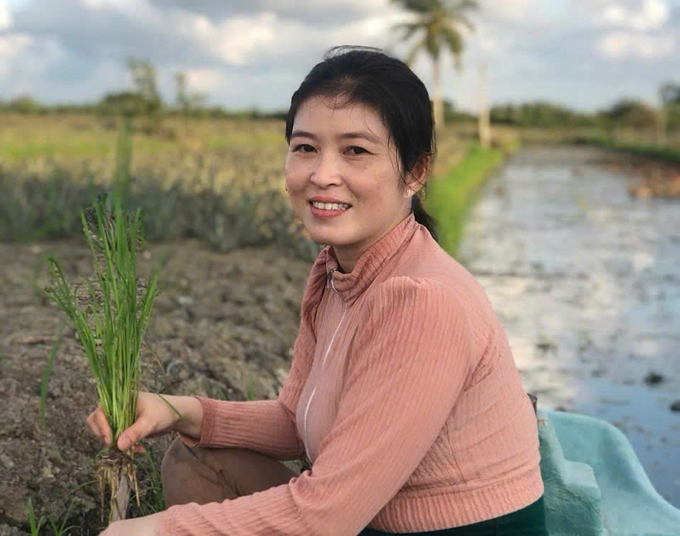 Nguyen Thi Kinh next to the ‘platform rice’ model in Vinh Phuoc A commune. Photo: Nhu Bang.