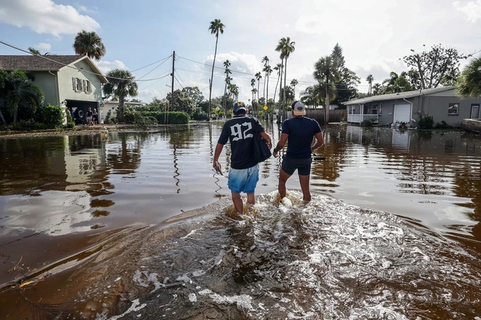 Người dân ở thành phố St. Petersburg, Florida, lội qua vùng nước lũ do cơn bão Helene hôm 5/10. Ảnh: AP.