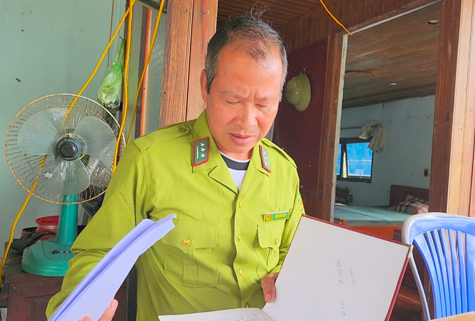 Vu Van Duy reviewing the patrol and forest fire prevention logs. Photo: Dinh Muoi.