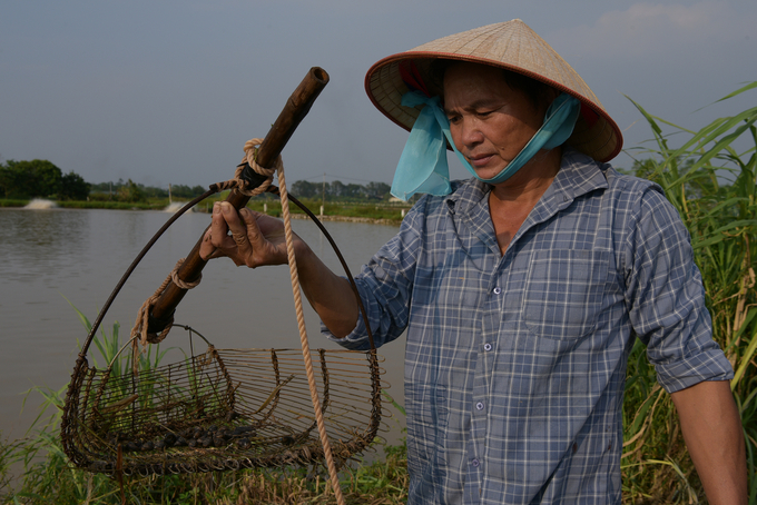 Anh Liêm bên chiếc cào bắt ốc. Ảnh: Dương Đình Tường.