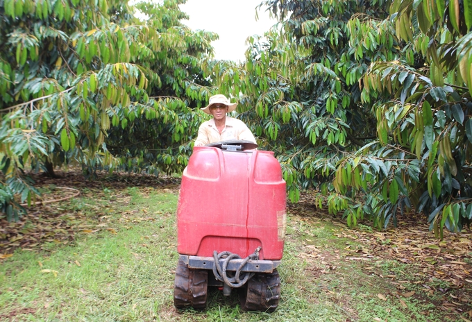 Phan Van Vinh using a sprayer for biological products in his farm. Photo: Tuan Anh.