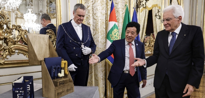 FAO Director-General QU Dongyu presents President Sergio Mattarella with a wooden rendition of the Food and Agriculture Museum and network logo along with an invitation to its inauguration.