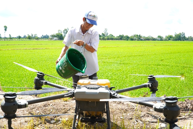 Nguyen Van Cuong utilizing a microbial product to eliminate algae and moss. Photo: Kim Anh.