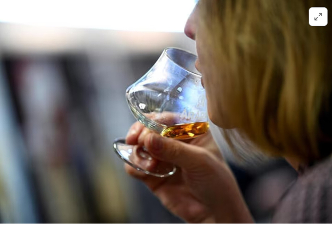 A woman drinks brandy during the International Green Week agriculture fair in Berlin, Germany, January 19, 2024.