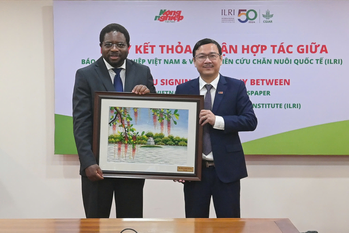 Mr. Nguyen Ngoc Thach, Editor-in-Chief of Vietnam Agriculture Newspaper, presented a souvenir picture to Professor Appolinaire Djikeng, Director General of the International Livestock Research Institute. Photo: Tung Dinh.