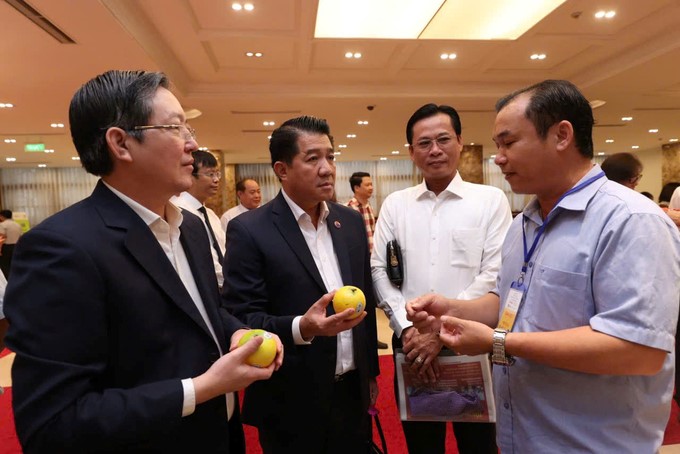 Mr. Vu Manh Hung, Chairman of Hung Nhon Group (second from left), and delegates visit the agricultural product booth on the sidelines of the forum.