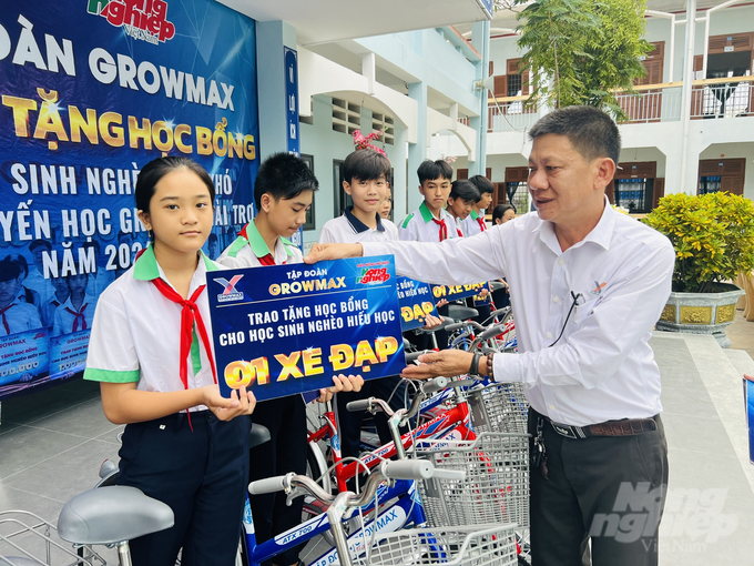 Ông Dương Văn Huy, đại diện Tập đoàn GrowMax trao tặng xe đạp cho học sinh trường THCS Trần Văn Ơn. Ảnh: Trọng Linh.