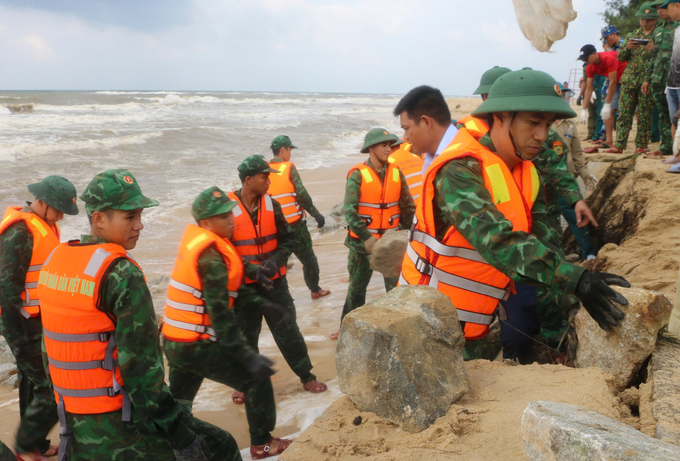 Lực lượng bộ đội tham gia khắc phục sạt lở bờ biển tại bãi tắm Phú Thuận chiều 22/10. Ảnh: CĐ.