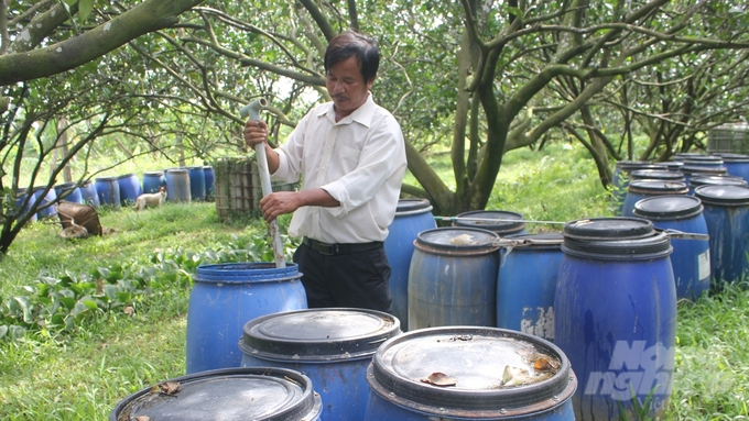 Anh Phan Thiên Đức bên hệ thống ủ phân hữu cơ vi sinh từ IMO. Ảnh: Trần Trung.