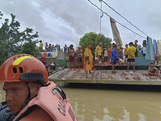 Nhiều người dân leo lên mái nhà để tránh lũ lụt do bão Trà Mi gây ra ở thị trấn Libon, tỉnh Albay, phía Nam Manila, ngày 23/10. Ảnh: Cảnh sát biển Philippines.