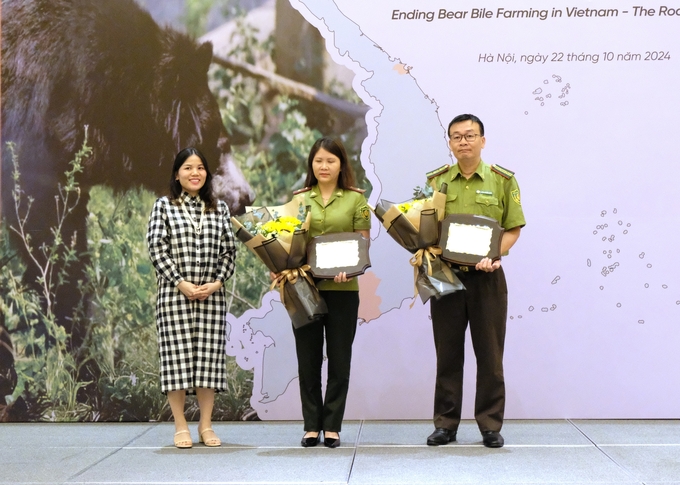 Ms. Bui Thi Ha (left), Deputy Director of ENV, presents a commemorative medal to the forest rangers. Photo: ENV.