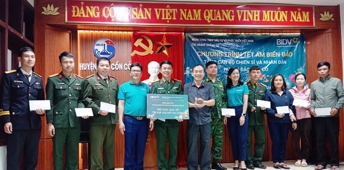 Cán bộ BIDV Chi nhánh Quảng Trị tặng quà cán bộ, chiến sĩ, nhân dân trên đảo Cồn Cỏ trước sự chứng kiến của lãnh đạo huyện. Ảnh: LQH.