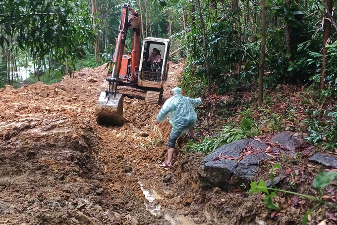 Xe cơ giới tạo mương chia nước trên đỉnh núi phía sau khu dân cư Nà Nổ. Ảnh: VN.