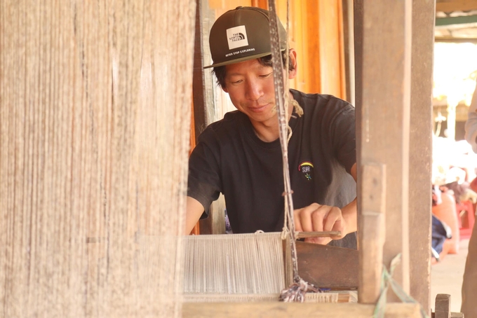 Mr. Hiroki is experiencing wax-painting. Photo: Thanh Tien. Photo: Thanh Tien.