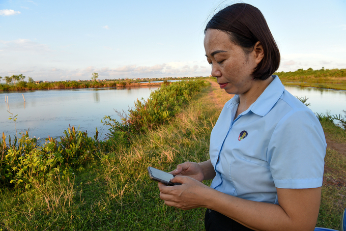 Mrs. Duoc reviews the script written by ChatGPT right by the pond. Photo: Duong Dinh Tuong.