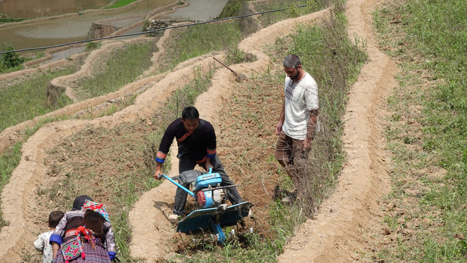 Mr. Giang A De shows how to plow the fields with a machine for tourists. Photo: Thanh Tien.