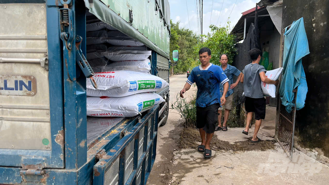 Cấp hỗ trợ thức ăn nuôi cá cho các hộ trong mô hình. Ảnh: Thu Hà.