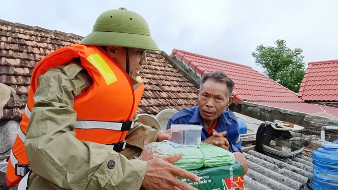 Cứu trợ cho bà con vùng đang bị ngập lũ tại huyện Quảng Ninh. Ảnh: T. Đức.