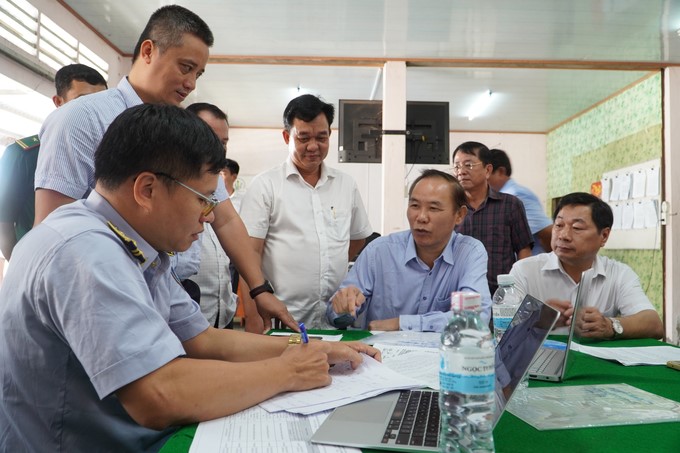 Deputy Minister of Agriculture and Rural Development Phung Duc Tien and leaders of Soc Trang province inspect the recording of fishing vessel management books. Photo: Kim Anh.