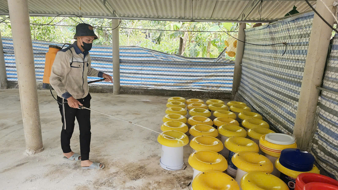 Anh Đỗ Văn Cường khử trùng chuồng gà và hy vọng được vay vốn tái thả đàn sớm khắc phục thiệt hại sau lũ quét. Ảnh: T. Đức.