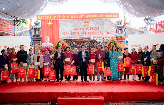 Ông Nguyễn Xuân Thắng cùng lãnh đạo địa phương tặng quà cho các hộ gia đình có hoàn cảnh khó khăn trên địa bàn. Ảnh: Ngọc Hiếu.