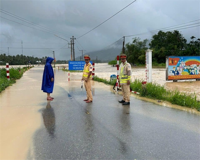 Công an huyện Hoài Ân (Bình Định) chốt chặn những điểm bị ngập lũ, không cho phương tiện và người qua lại. Ảnh: V.Đ.T.