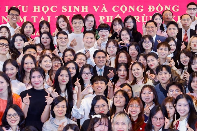 Thủ tướng chụp ảnh cùng các lưu học sinh và cộng đồng người Việt Nam tại thành phố Trùng Khánh. Ảnh: VGP.