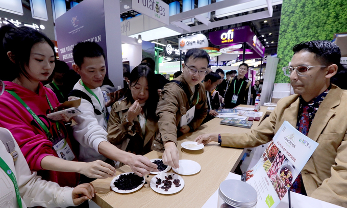 Visitors taste dried cherries at an exhibition booth in the American Food and Agriculture Pavilion at the 7th China International Import Expo on November 8, 2024. The pavilion has an exhibition area of 240 square meters, showcasing various agricultural products from multiple US companies and organizations. Photo: Chen Xia/GT.