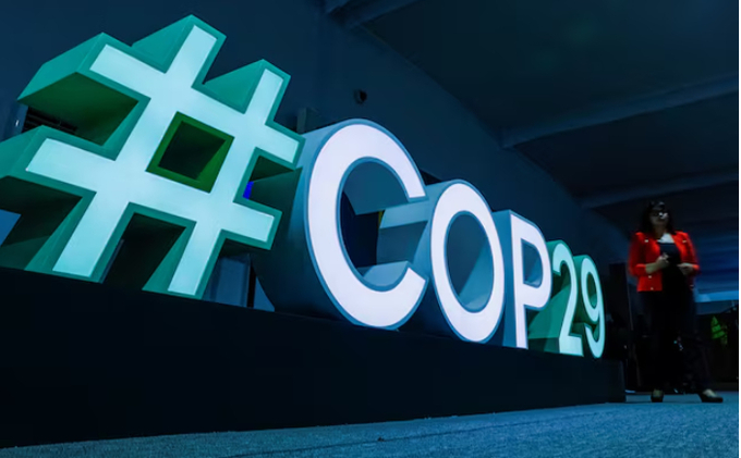 A woman passes by a #COP29 sign during the United Nations climate change conference COP29 in Baku, Azerbaijan November 11, 2024.