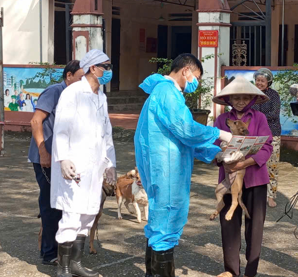 Người dân đưa chó, mèo đến nhà văn hóa thôn để tiêm phòng dại. Ảnh: QT.