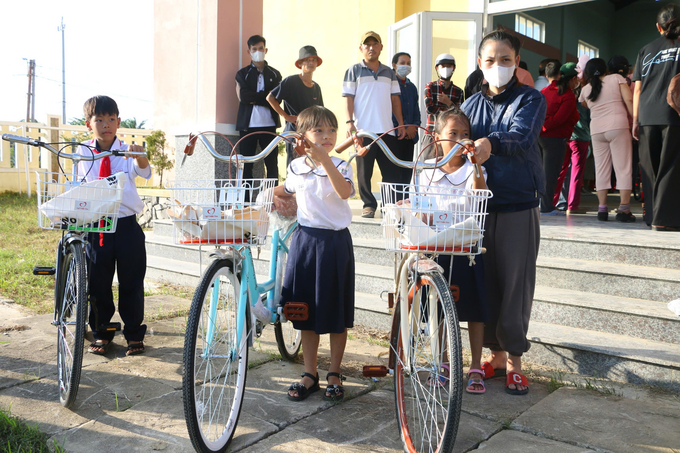 Phụ huynh học sinh và các em tại huyện Phú Vang cùng nhận xe đạp được trao tặng. Ảnh: Công Điền.