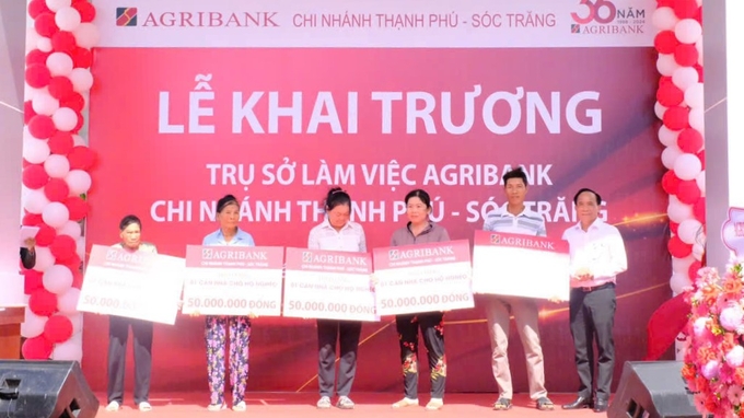 Đại diện Agribank Sóc Trăng trao bảng tượng trưng, hỗ trợ xây dựng 5 căn nhà cho hộ nghèo khó khăn về nhà ở trên địa bàn huyện Mỹ Xuyên. Ảnh: Minh Khương.