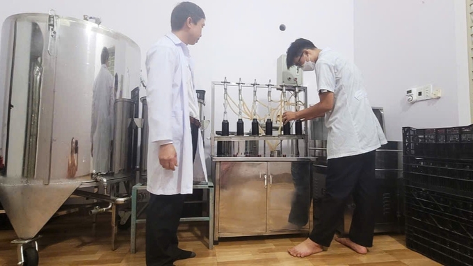 Nguyen Van Manh overseeing the process of medicinal herb extraction and bottling. Photo: Nguyen Thanh.