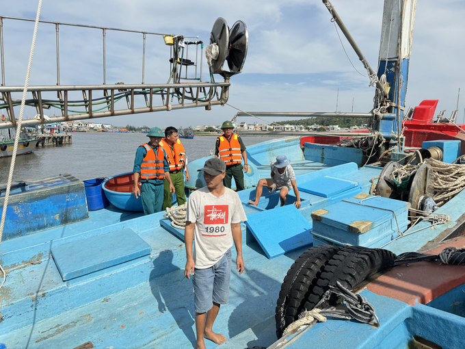 Lực lượng Bộ đội Biên phòng Quảng Ngãi giúp ngư dân chằng chống cột tàu thuyền phòng tránh bão. Ảnh: Kim Sơ.