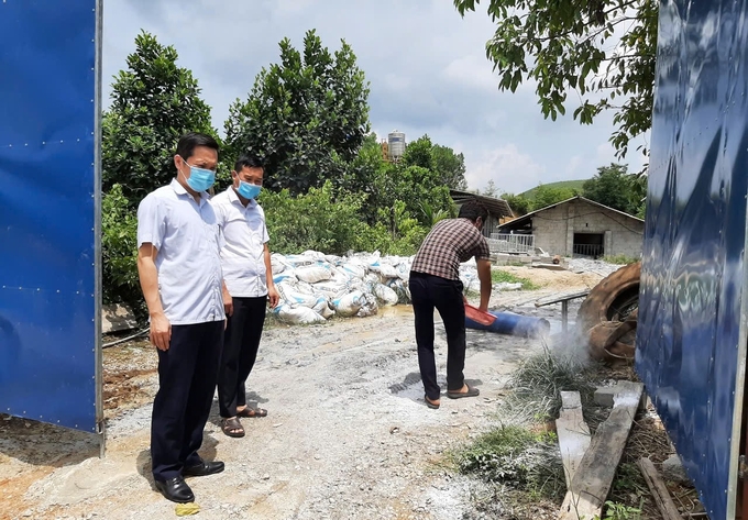 Chi cục Chăn nuôi, Thú y và Thủy sản tỉnh Thái Nguyên hướng dẫn người chăn nuôi áp dụng các biện pháp vệ sinh, khử trùng khu vực chuồng nuôi và khu vực xung quanh có nguy cơ cao. Ảnh: Phạm Hiếu.