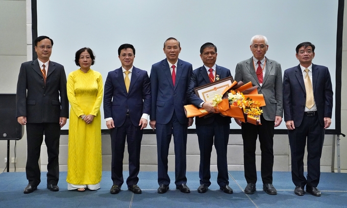 Deputy Minister of MARD, Mr. Phung Duc Tien congratulated Dr. Ronello Abila alongside leaders of the Department of Animal Health. Photo: Bao Thang. 