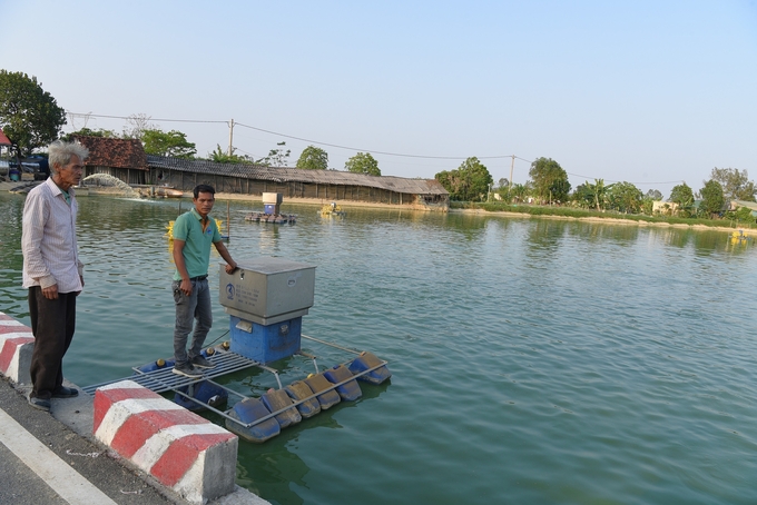 The father and son duo, Le Xuan Bong and Le Quang Khai, working on the fish farm. Photo: Duong Dinh Tuong.