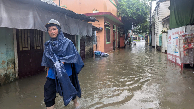 Một người dân ở phường Hương Vinh, thành phố Huế di chuyển trên tuyến đường ngập lụt. Ảnh: Công Điền.