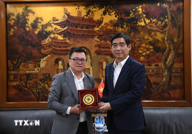 Mr. Le Quoc Minh (left) and the Vietnamese Ambassador to Thailand, Pham Viet Hung, exchange souvenirs. Photo: TTXVN.