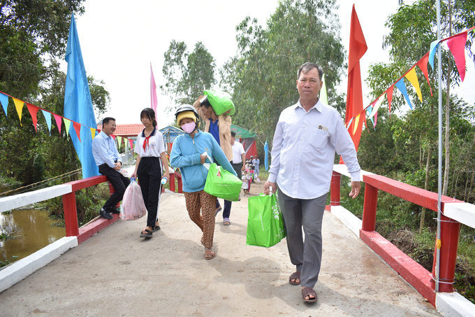 Người dân xã Thủy Đông, huyện Thạnh Hóa đi trên cầu Rạch Lò mới. Ảnh: Minh Đảm.