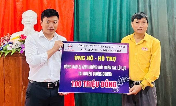 Ông Lữ Văn Thành (áo vàng), Phó Chủ tịch Ủy ban Mặt trận Tổ quốc huyện Tương Dương, tiếp nhận ủng hộ từ Nhà máy Thủy điện Khe Bố. Ảnh: An Nhiên.