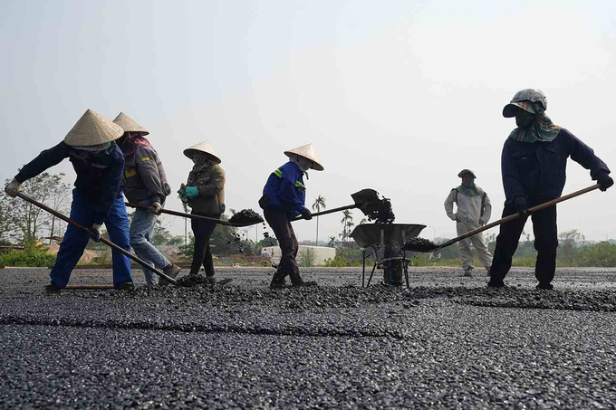 Công nhân thi công hạng mục thảm nhựa mặt đường. Dự kiến đến tháng 12 sẽ có 2 dây chuyền bê tông nhựa hoạt động. Ảnh: Hữu Chánh.